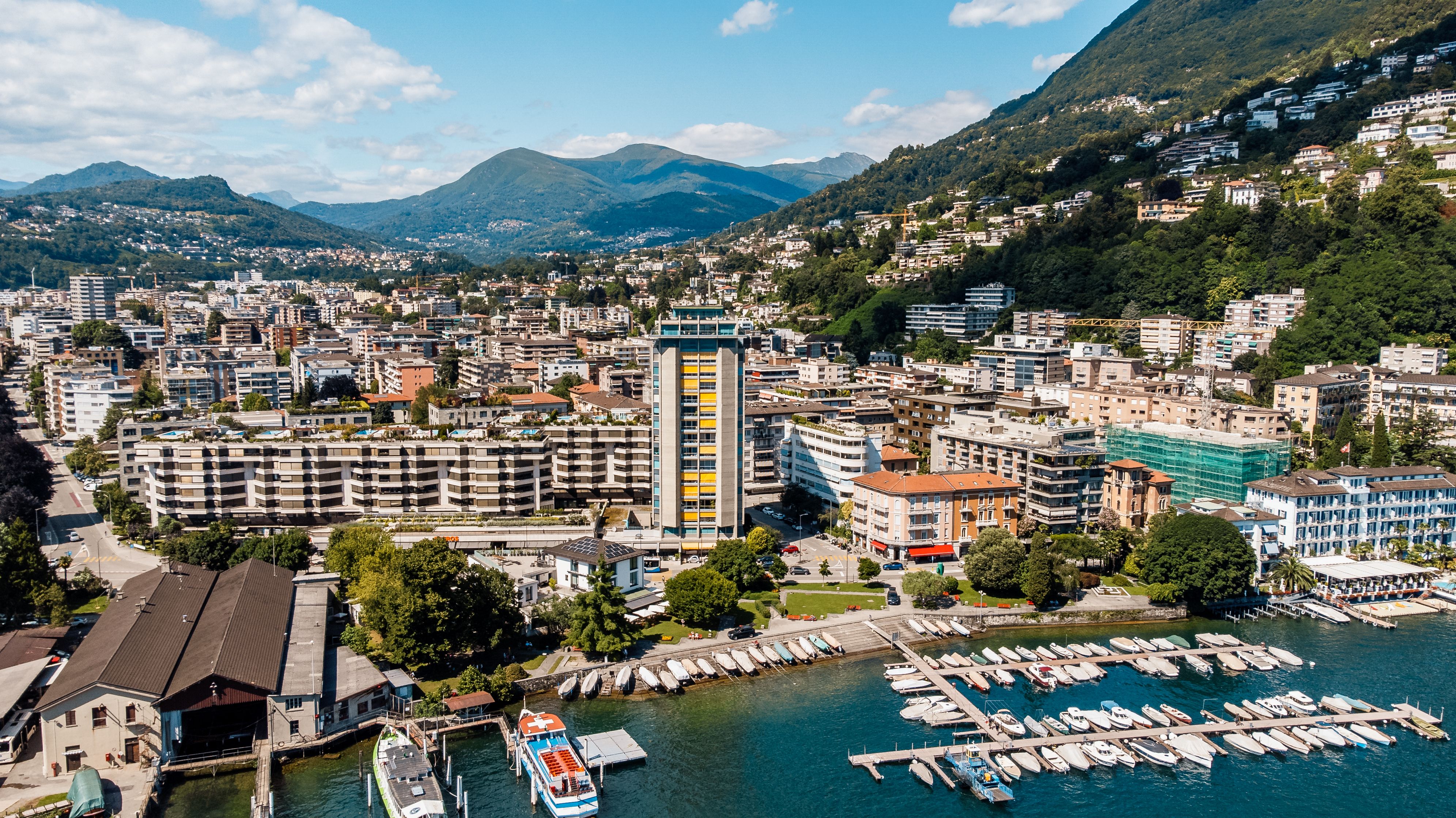 Luftaufnahme von Lugano mit Stadt, Berghängen und Uferbereich